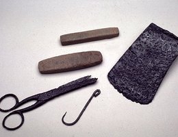 Trade goods include whetstones for sharpening metal tools (top center) as well as an ax head, fish hook, and scissors
