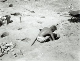 Archeologist digging in storage pits at Crow Creek Massacre site, South Dakota, 1954