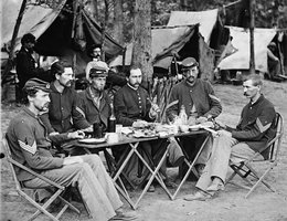 Civil War soldiers eating outside at a tent camp, circa early 1860s