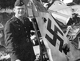 Major Carlyle Wilson, 78th Fighter Group, with Nazi plane wreckage; Wilson was a physician, born in Dunning, NE, and later a resident of Omaha, NE