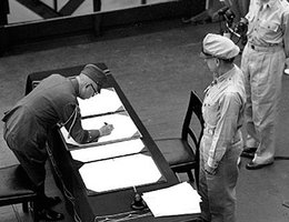 General Yoshijiro Umezu, Chief of the Army General Staff, signs the Instrument of Surrender on behalf of Japanese Imperial General Headquarters, on board USS Missouri (BB-63), September 2, 1945